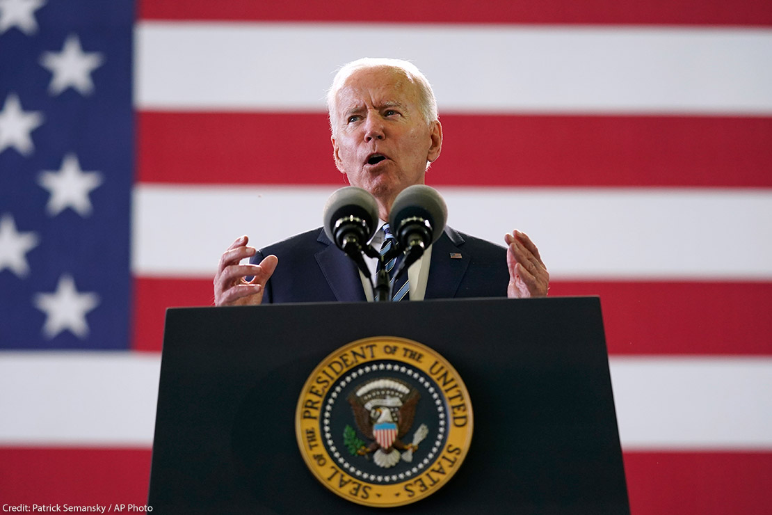 President Joe Biden speaks behind podium to American service members in England