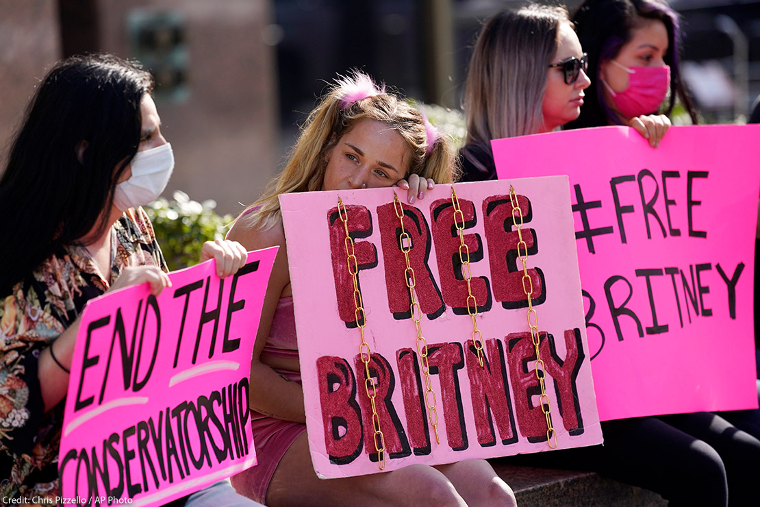 Britney Spears' supporters sit outside holding signs that read "Free Britney" and "End the Conservatorship" during a court hearing concerning the pop singer's conservatorship