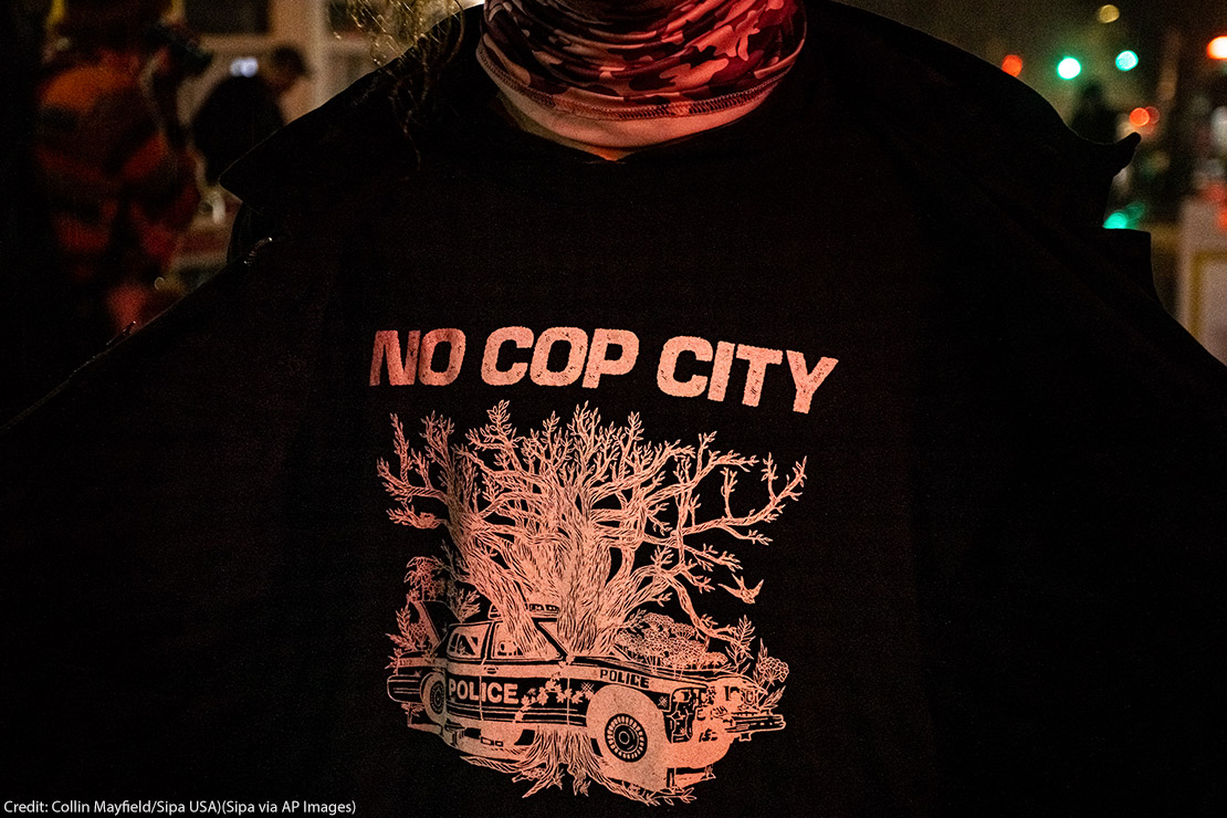 A protestor wearing a t shirt that says No Cop City.