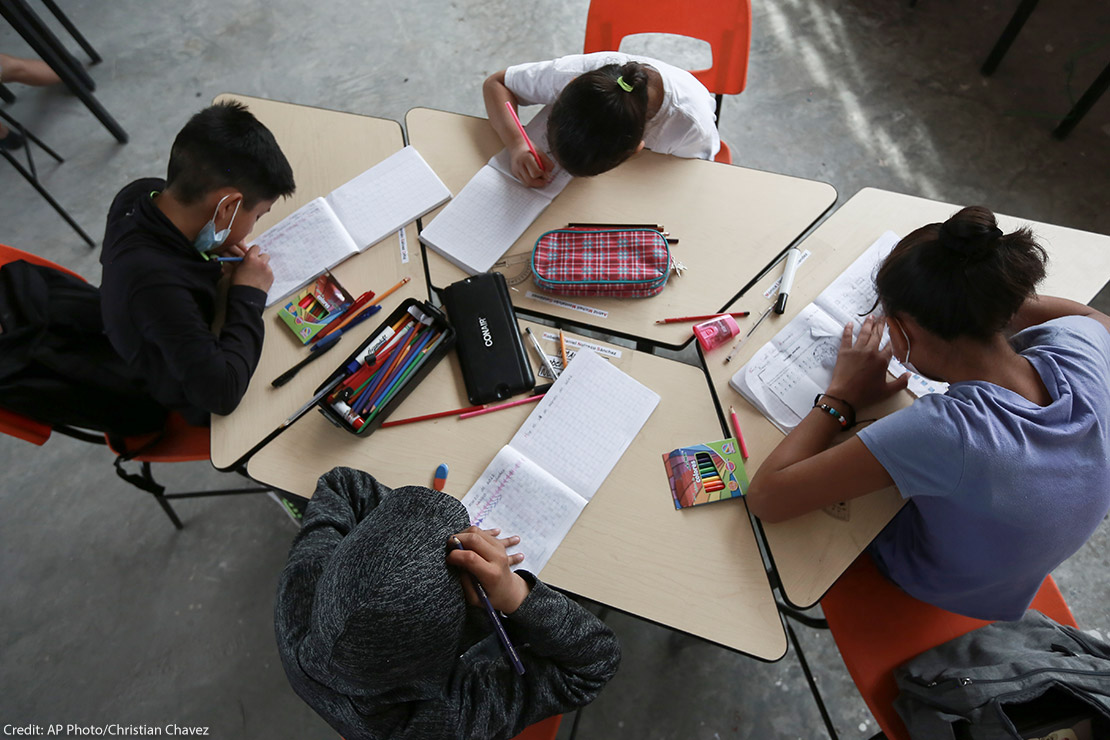 Migrant children working inside a classroom.