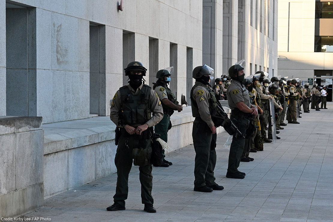 Police force stands guard in riot gear in front of Hall of Justice in Los Angeles.