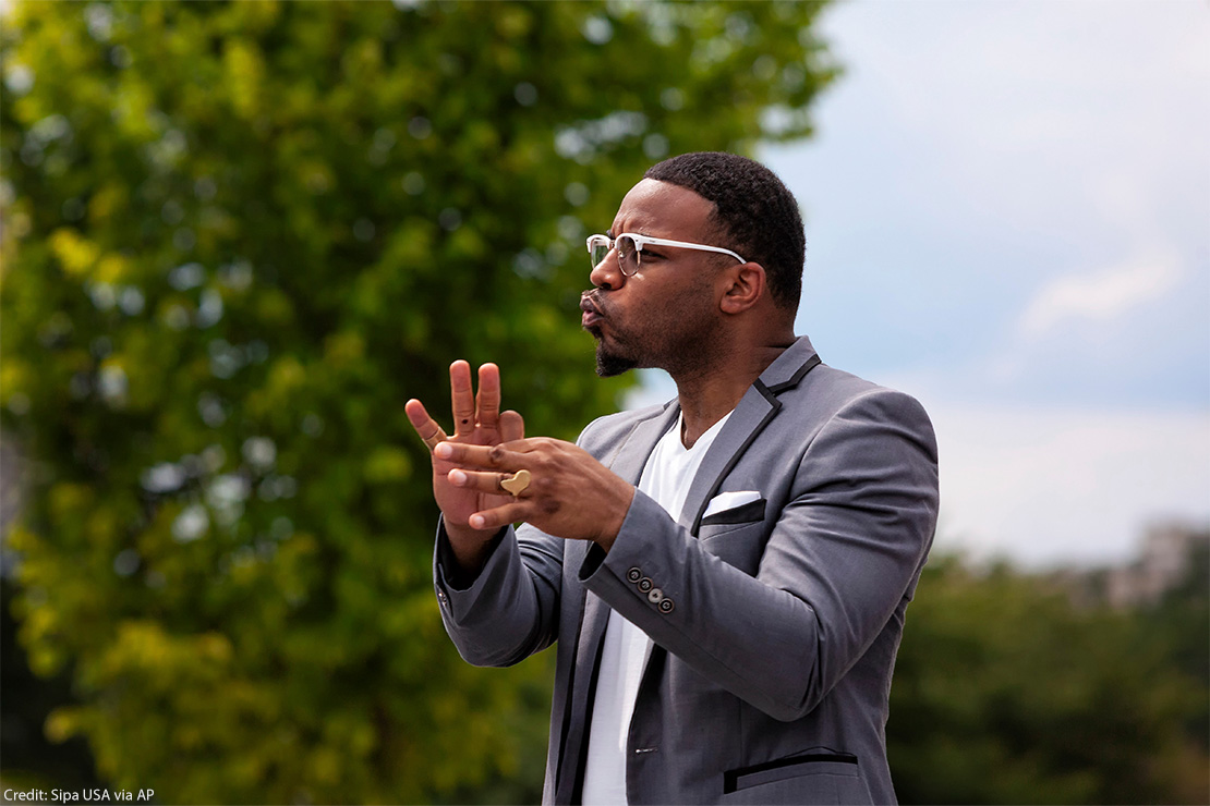 An American Sign Language interpreter interpreting at an anti-racism rally and march.