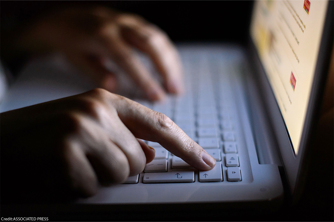 A person using a laptop with just their fingers showing.