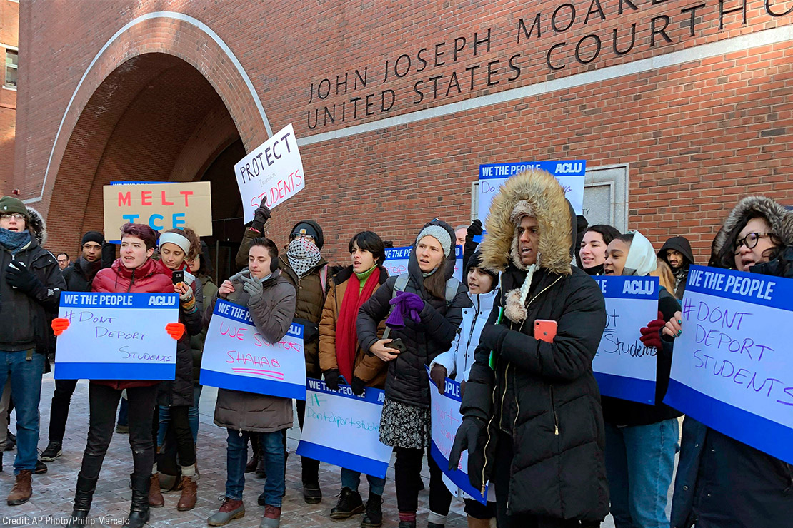 Protesters stand outside the federal courthouse where a hearing was scheduled for Northeastern University student Shahab Dehghani