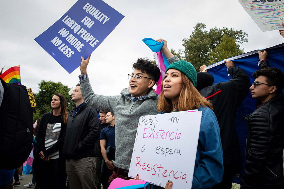 Demonstrators carrying signs advocating for the rights of LGBTQ people.