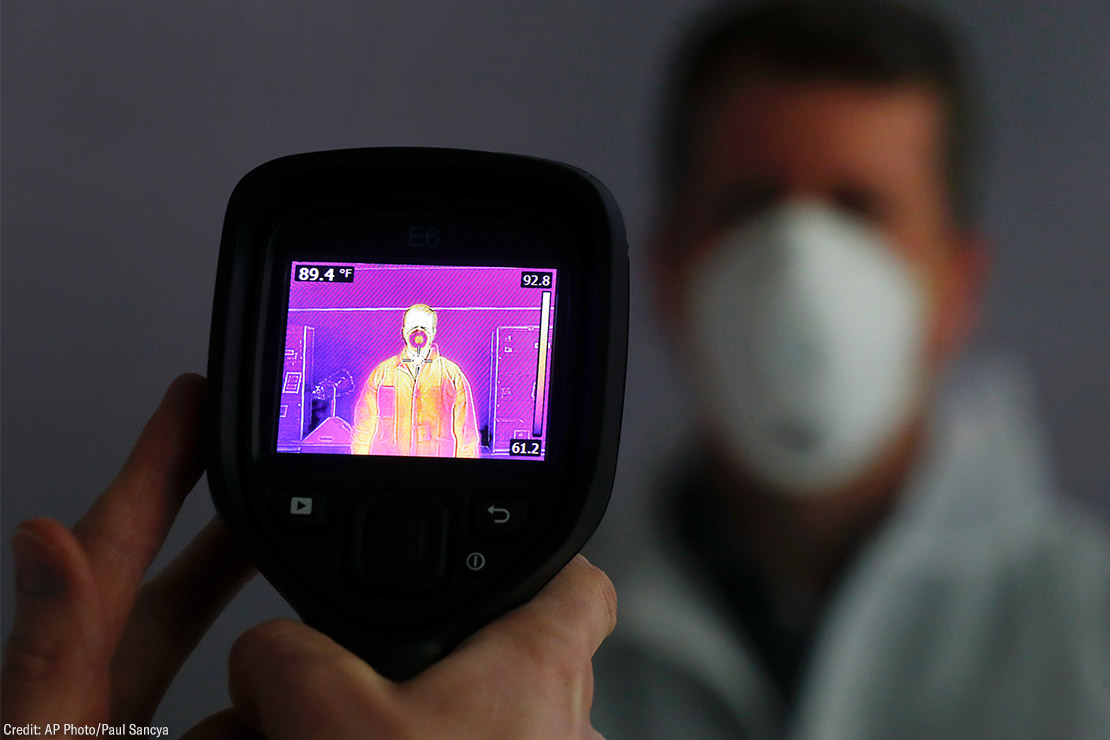 An infrared camera is shown scanning a person for elevated body temperature.