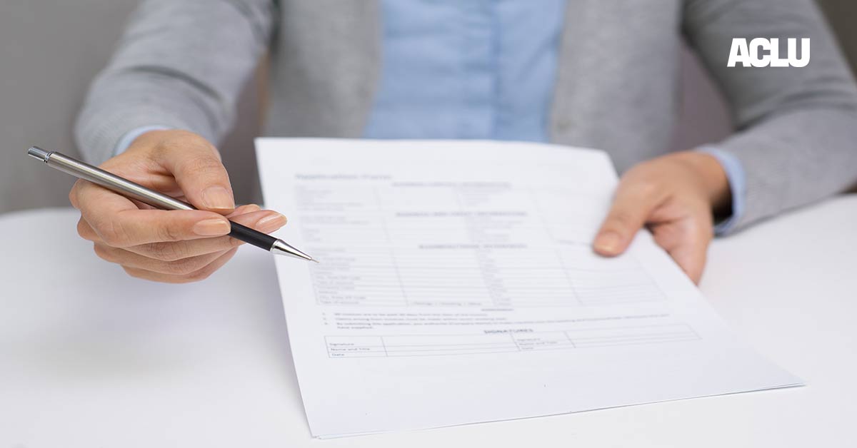 Image of a hand offering a pen to sign a document