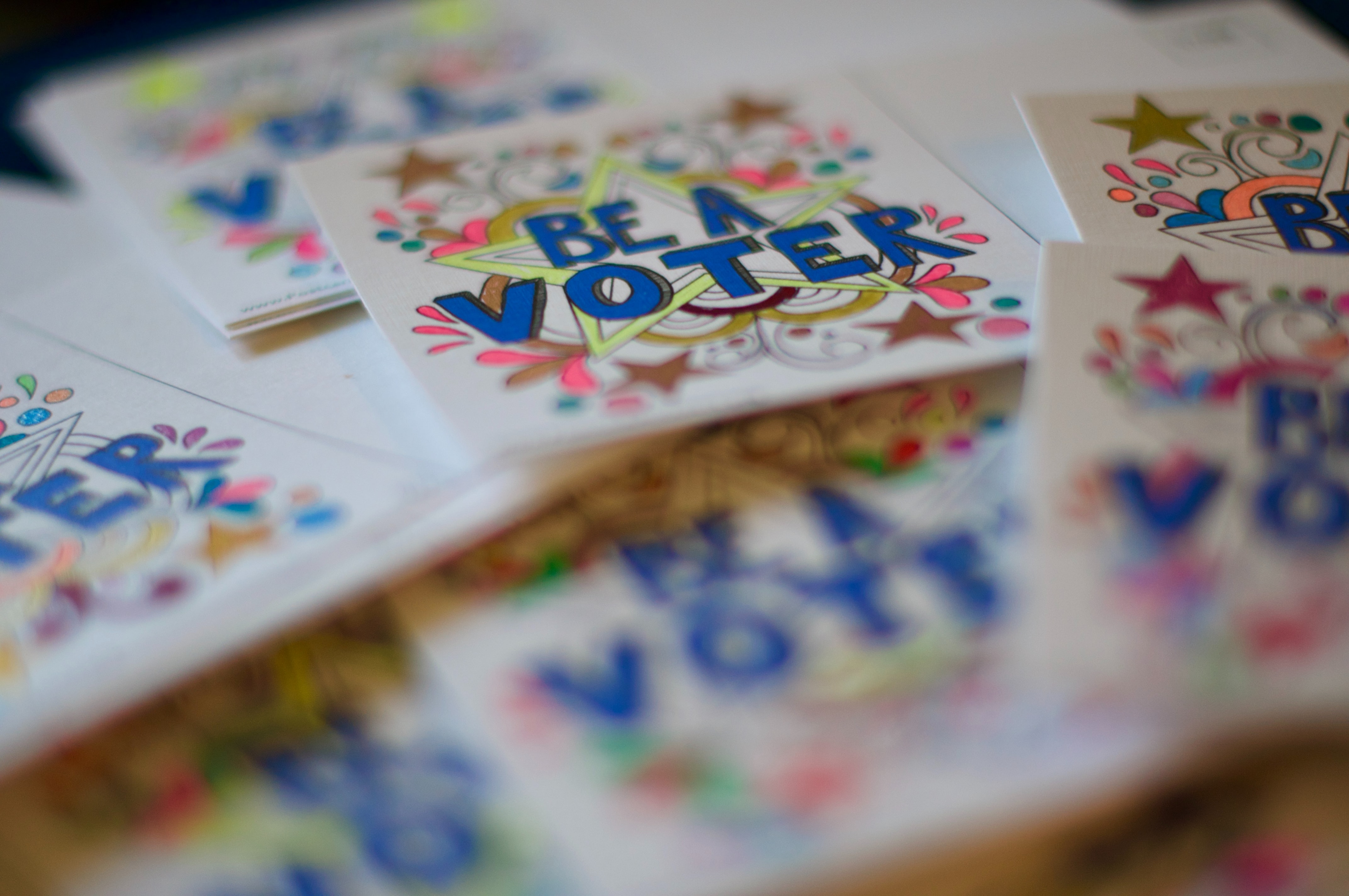 The words "Be a Voter" on a colorful sticker 