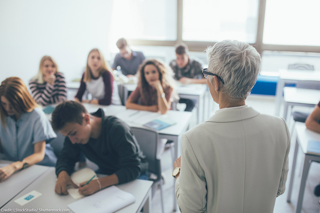 A professor in front of a class full of students.