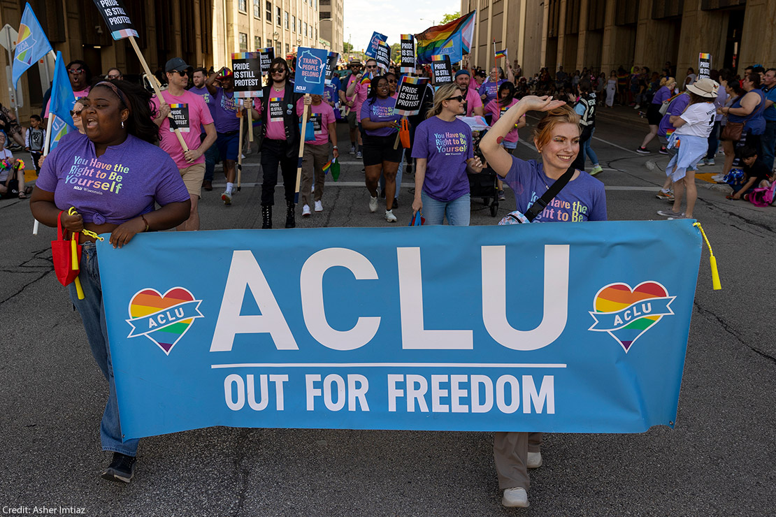 Two demonstrators holding a sign that says "ACLU Out For Freedom."