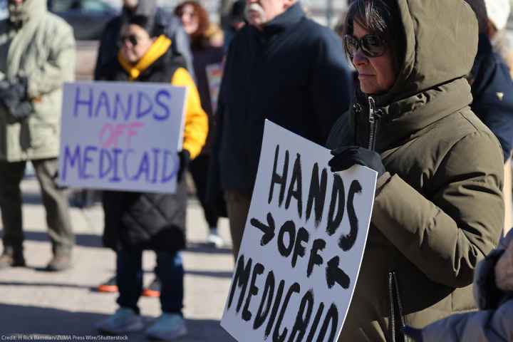 Demonstrators holding signs that read "HANDS OFF MEDICAID" protest the Trump administration's plan to roll back Medicaid expansion during a rally in front of the DuPage County Court House in Illinois.