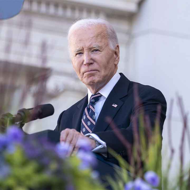 President Biden stares into the camera from behind a podium.