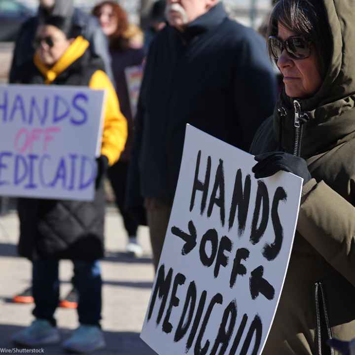 Demonstrators holding signs that read "HANDS OFF MEDICAID" protest the Trump administration's plan to roll back Medicaid expansion during a rally in front of the DuPage County Court House in Illinois.