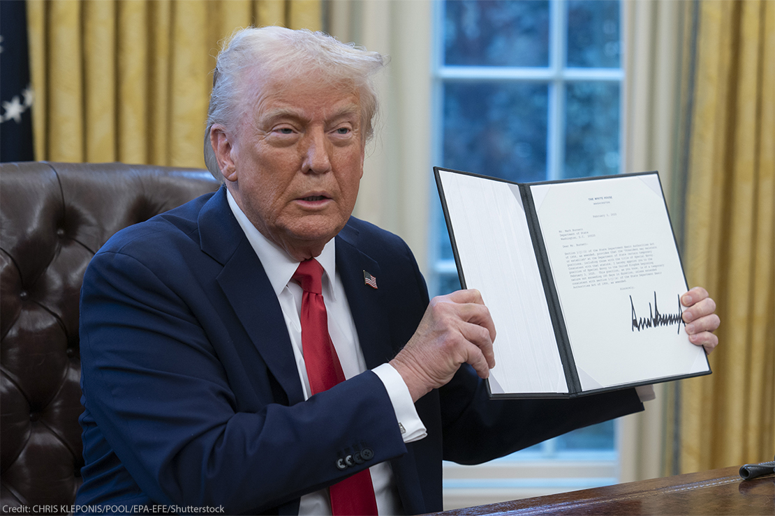 President Donald Trump holds up a recently signed executive order in the Oval Office of the White House.