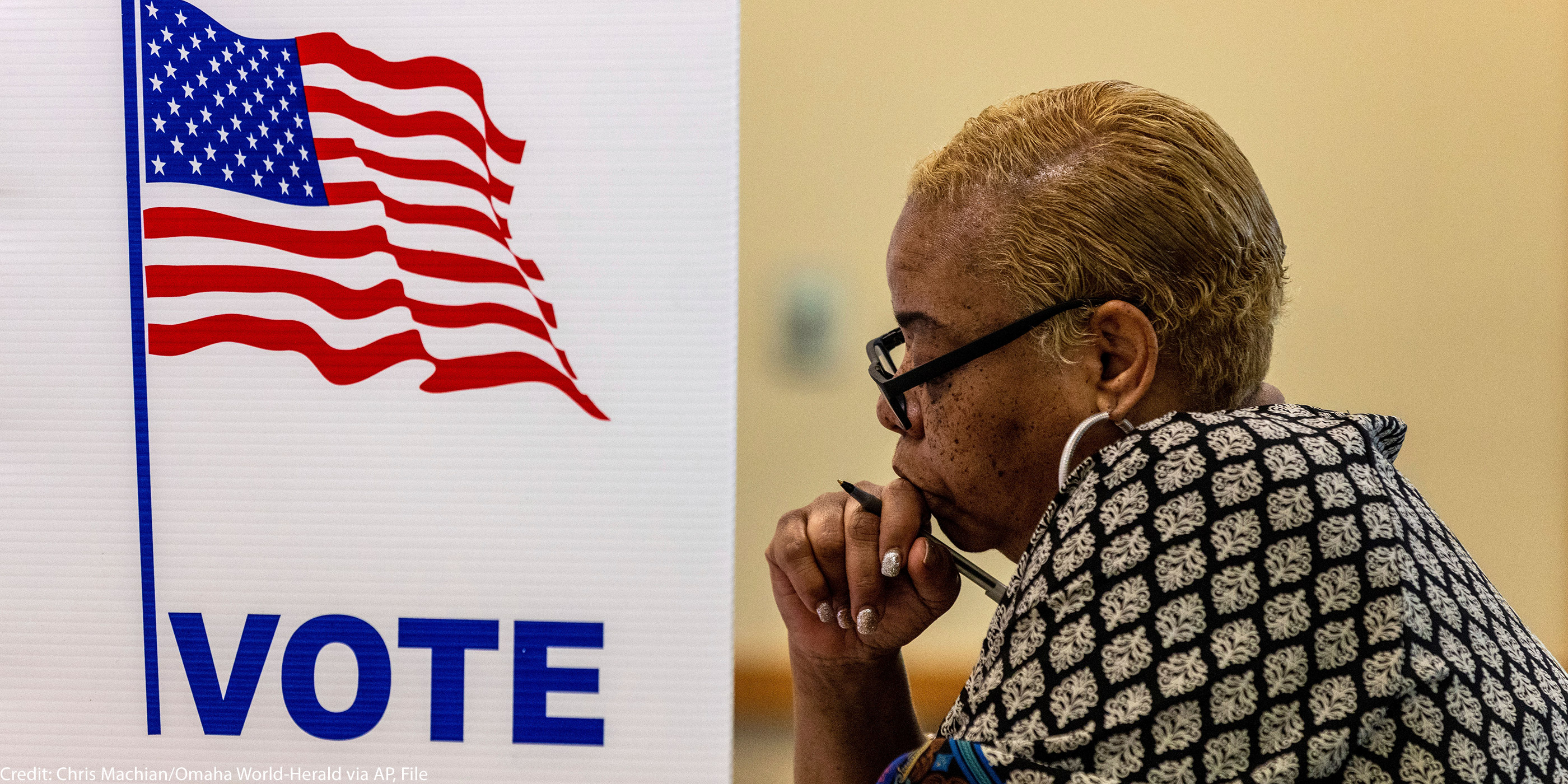 A profile view of a woman in a voting booth.