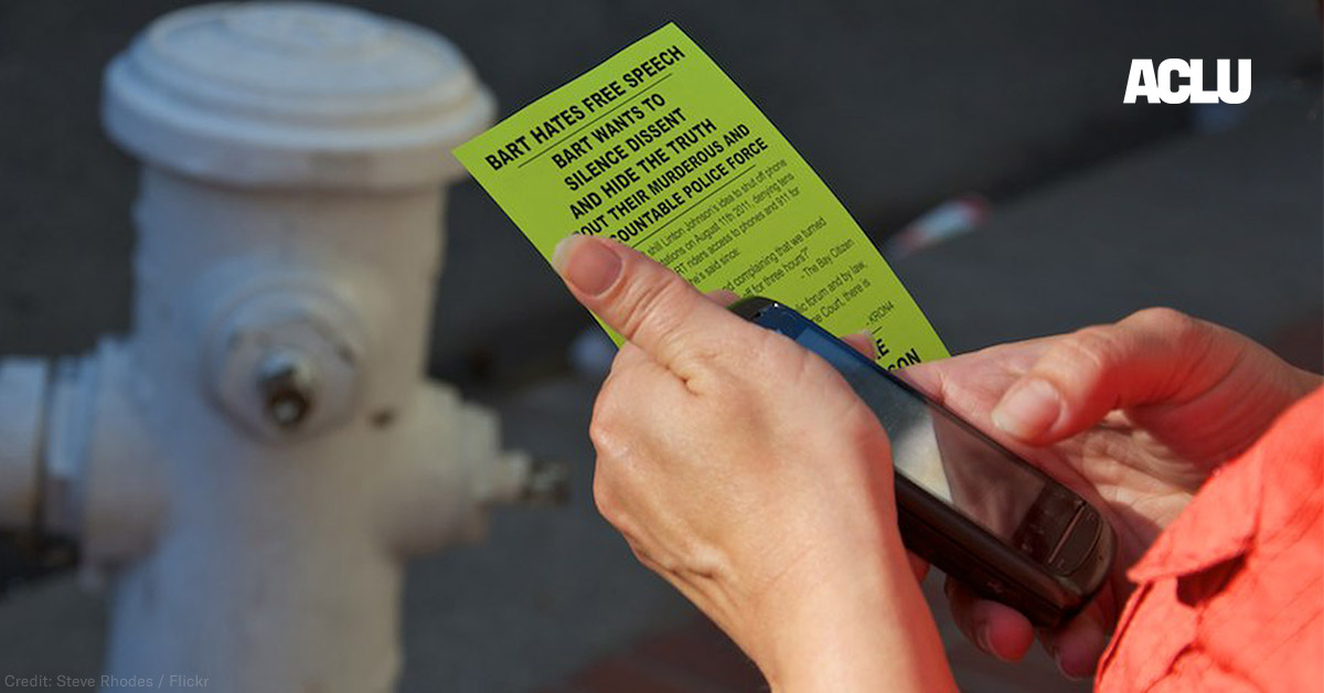 Person holding cell phone and flyer