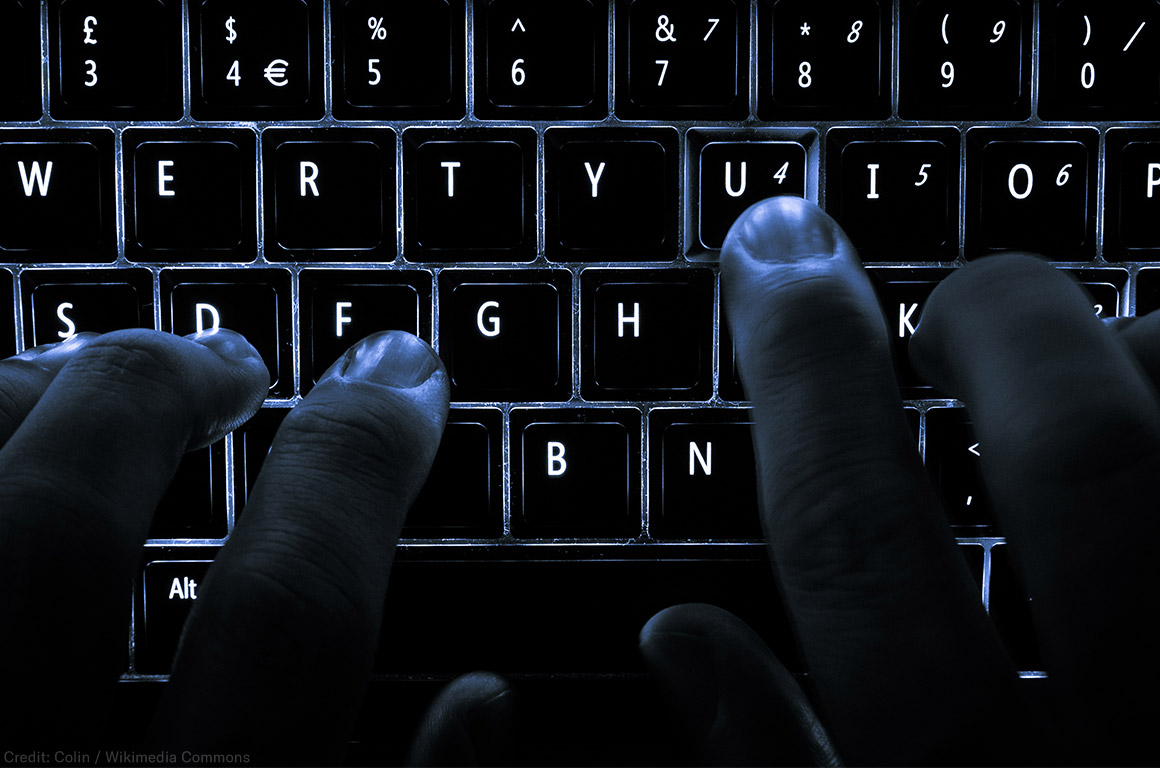 A backlit laptop computer keyboard. Most fingers are on the &quot;home&quot; keys for touch-typing; the &#039;U&#039; key is being pressed.