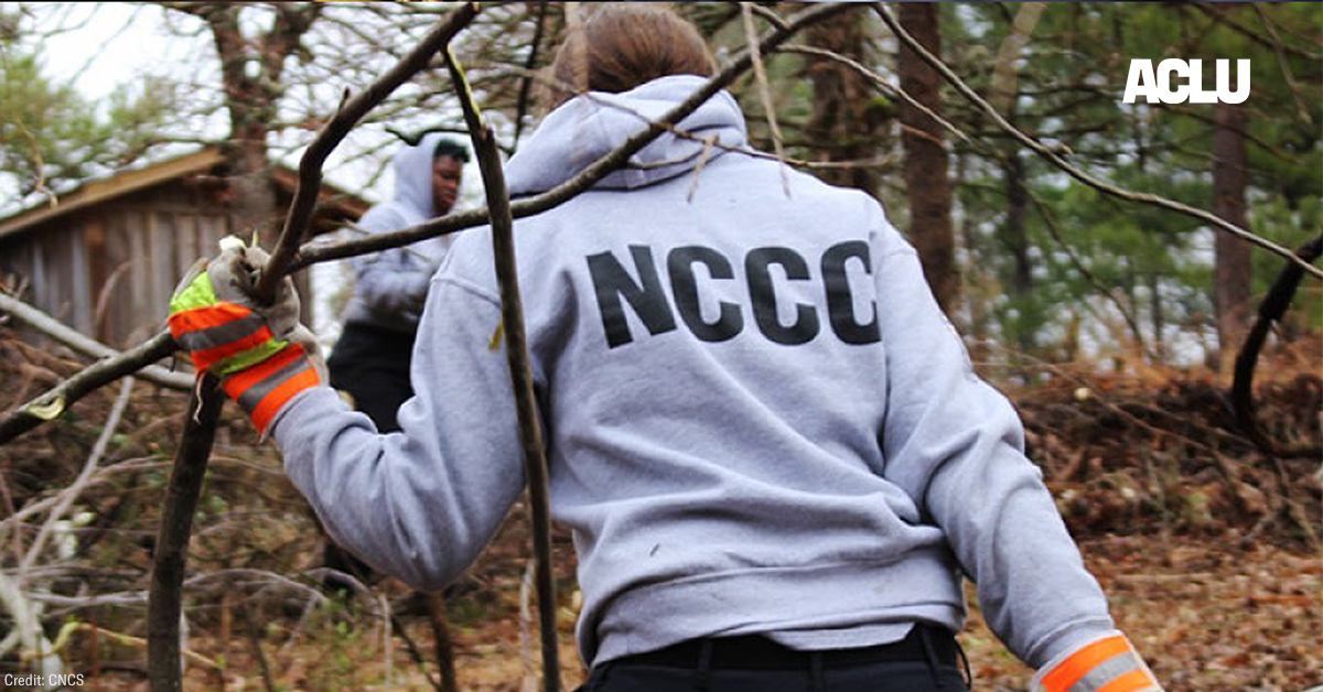 A NCCC worker hauling branches