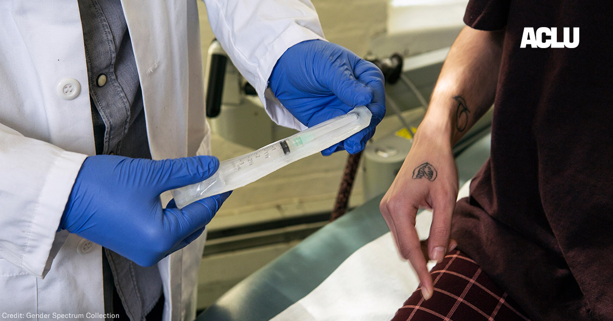 A doctor showing a patient a syringe used to inject testosterone